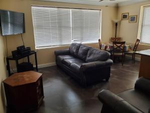 a living room with a leather couch and a table at One Bedroom Downtown in Jacksonville +7 photos