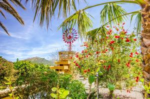 a garden with a windmill and red flowers at Luxury Villa Es Molinet in Alcudia +28 photos