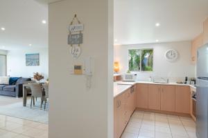 - deux vues sur une cuisine et un salon dans l'établissement Phil's Place on Airlie, à Airlie Beach