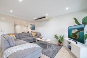 un salon avec un canapé et une télévision dans l'établissement Phil's Place on Airlie, à Airlie Beach