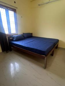 a large bed in a room with a blue mattress at SNR Anugraha Residency in Tiruvannāmalai