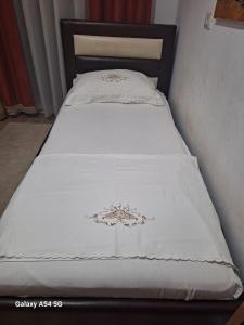 a bed with a white blanket on top of it at Best Apartment in Valjiosi