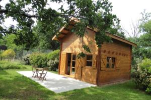 a log cabin with a table and chairs in a yard at Les Chalets du Manoir in Montauban