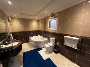 a bathroom with a toilet and a sink and a tub at بيت الضيافة in Jeddah