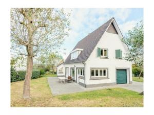 a white house with a gambrel roof at Holiday home in De Panne with barbecue in De Panne