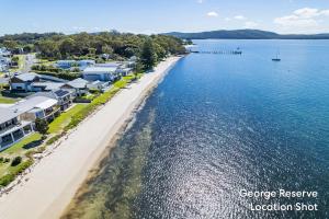 an aerial view of a beach with houses and the water at Casuarinas 5 superb waterfront unit in Soldiers Point +16 photos