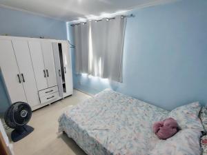 a blue bedroom with a bed and a dresser and a bed sidx sidx sidx at Apto pé na Areia 2 in Ilha do Frade