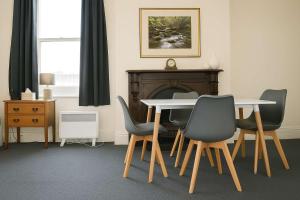 a table and chairs in a room with a fireplace at Comfy Apartment with carpark 2 minutes to CBD in Hobart