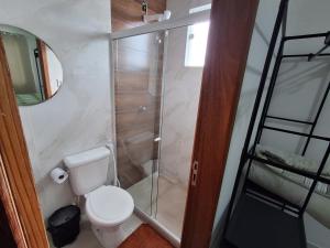 a bathroom with a toilet and a glass shower at Casa Novinha na Praia in Cabo Frio