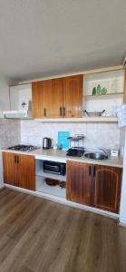 a kitchen with a stove and a sink and wooden cabinets at Cond Bahia Pelicano in Puchuncaví