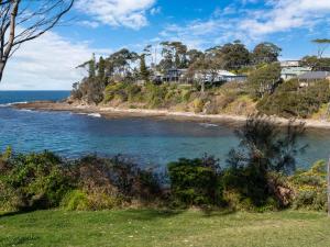 a beach with houses on a hill next to the ocean at Oceanfront Beauty in Lilli Pilli in Surf Beach +23 photos
