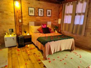 a bedroom with a bed with flowers on it at Suítes Rústicas Campos do Jordão - Com banheira de hidromassagem in Campos do Jordão