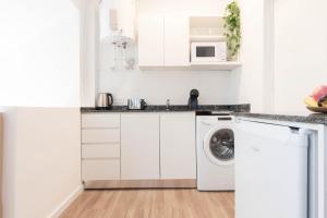 une cuisine blanche avec une machine à laver à l'intérieur dans l'établissement Fliphaus Libertador 6300 B - RiverPlate Stadium, à Buenos Aires