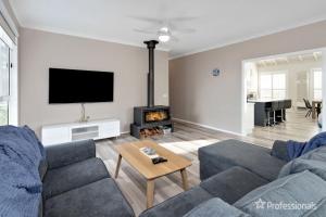 una sala de estar con un sofá y una chimenea en Two Salty Dogs, en Surf Beach