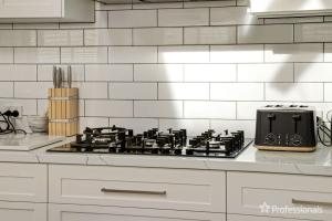 una cocina con estufa y tostadora en Two Salty Dogs, en Surf Beach