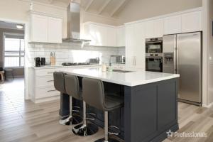 una gran cocina blanca con una gran isla con taburetes en Two Salty Dogs, en Surf Beach 22 fotos más