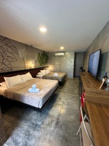 a bedroom with two beds and a flat screen tv at Eco Hotel La Colina Mirador Con aire acondicionado in Quimbaya