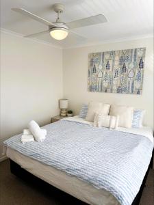 a bedroom with a large bed with a ceiling fan at 9 By the Clyde, Central Location in Batemans Bay in Batemans Bay +15 photos