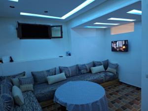 a living room with a couch and a tv at La Pause Dar Bouazza in Tamaris