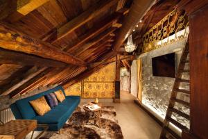 sala de estar con techos de madera y sofá azul en Villa Alceo, en Viggiù