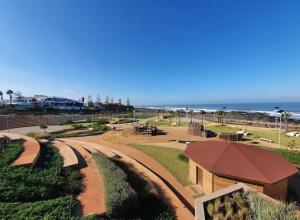 a view of a park with the ocean in the background at La Pause Dar Bouazza in Tamaris