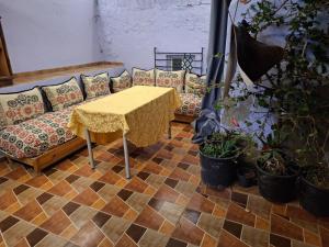 a couch and a table with a table and potted plants at La Pause Dar Bouazza in Tamaris