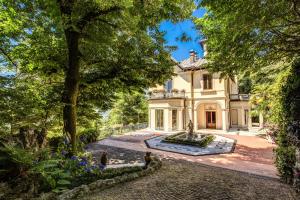 una vista exterior de una mansión con una fuente en Villa Alceo, en Viggiù