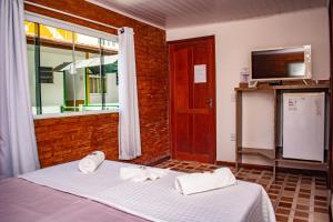 a bedroom with a bed and a window and a tv at Pousada Klein in Lumiar
