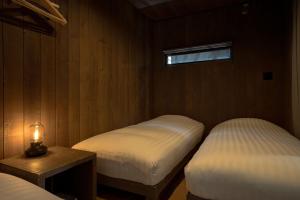 una camera con due letti e una candela su un tavolo di Tiny Base The River HOUSE & TRAILER a Kawazu