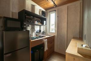 una cucina con frigorifero nero e lavandino di Tiny Base The River HOUSE & TRAILER a Kawazu