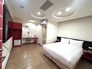 a bedroom with a large white bed and a kitchen at 柜富賓王旅店-台北館 Giant Rich King Plaza Hotel in Taipei +54 photos