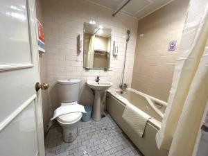 a bathroom with a toilet and a sink and a tub at 柜富賓王旅店-台北館 Giant Rich King Plaza Hotel in Taipei