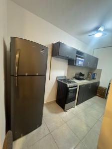 a kitchen with a stainless steel refrigerator and a stove at DEPARTAMENTO ARRECIFES PLAYA MIRAMAr in Madero