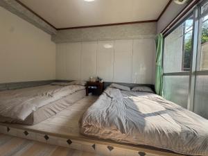 a bedroom with two beds and a window at 和風2西北口 in Tokyo