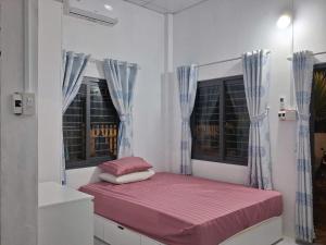 une petite chambre avec un lit et deux fenêtres dans l'établissement O'SEN Homestay, à Phước Hậu (1)