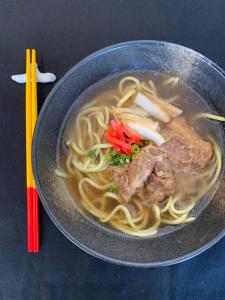 فندق إيست تشاينا سي في جزيرة إيشيغاكي: وعاء من الحساء مع اللحم والمعكرونة مع عيدان تناول الطعام