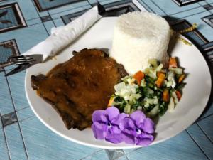 a plate of food with rice and vegetables on a table at Lonnoc ocean view beach bungalows in Hog Harbour