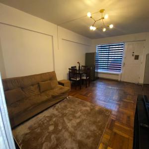 una sala de estar con un sofá y una mesa en CASA ROMÁN Departamento en Providencia para 3 personas, en Santiago