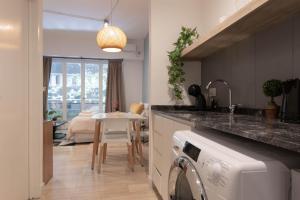 a kitchen with a sink and a washing machine at Fliphaus ChicHaus 9 Lux Units 36 pax Daily Housekeeping! in Buenos Aires +30 photos