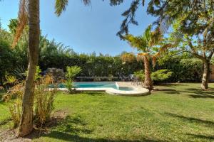 a swimming pool in a yard with palm trees at Fliphaus Alzaga 5100 - 4 Bd House Pool BBQ Daily Housekeeping! in Mendoza