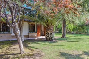 a house with a group of trees in the yard at Fliphaus Alzaga 5100 - 4 Bd House Pool BBQ Daily Housekeeping! in Mendoza