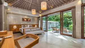 a bedroom with a bed and a living room at Mawar villa Ubud in Ubud