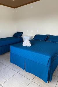 ein blaues Bett mit zwei Kissen darüber in der Unterkunft Chácara Cidade da Divina Misericórdia in Araucária