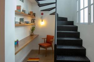a staircase in a room with a chair and a window at Fliphaus Nicaragua 5800 - Duplex with Patio in Palermo Hollywood in Buenos Aires +23 photos