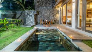 a pool in a backyard with a table on a deck at Mawar villa Ubud in Ubud