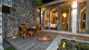 a patio with a table and chairs next to a pool at Mawar villa Ubud in Ubud