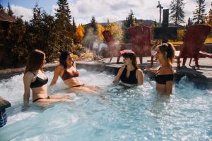 a group of women sitting in a hot tub at Les Hébergements de l'Éternel in Saint-David-de-Falardeau