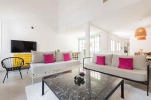 a living room with two white couches and pink pillows at Fliphaus Villa Soho Vibes - Lux House Palermo Soho in Buenos Aires