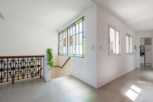 a white hallway with a window and a staircase at Fliphaus Villa Soho Vibes - Lux House Palermo Soho in Buenos Aires