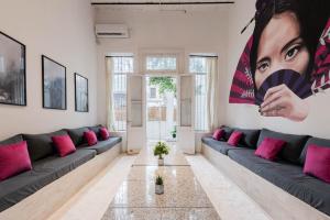 sala de estar con sofá azul y almohadas rosas en Fliphaus Villa Teodoro Garcia 2100 - 6 Bd Embassies Zone, en Buenos Aires